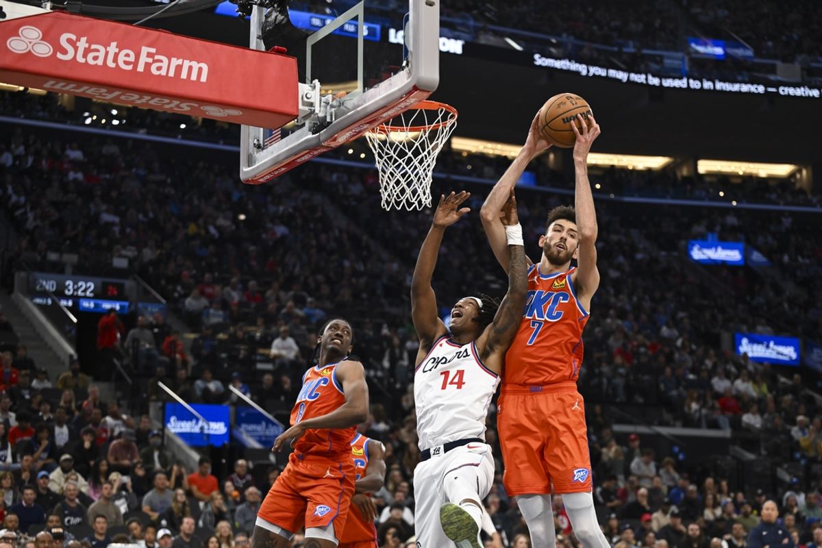 Nov 2, 2024; Inglewood, California, USA; Oklahoma City Thunder forward Chet Holmgren (7) rebounds against LA Clippers guard Terance Mann (14) during the first half at Intuit Dome. Mandatory Credit: Jonathan Hui-Imagn Images