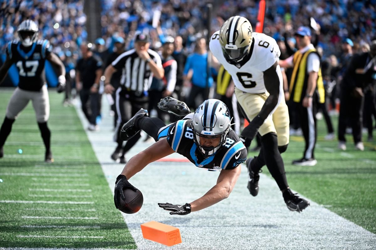Nov 3, 2024; Charlotte, North Carolina, USA; Carolina Panthers wide receiver Jalen Coker (18) reaches for the pylon as New Orleans Saints linebacker Willie Gay (6) defends in the second qarter at Bank of America Stadium. Mandatory Credit: Bob Donnan-Imagn Images