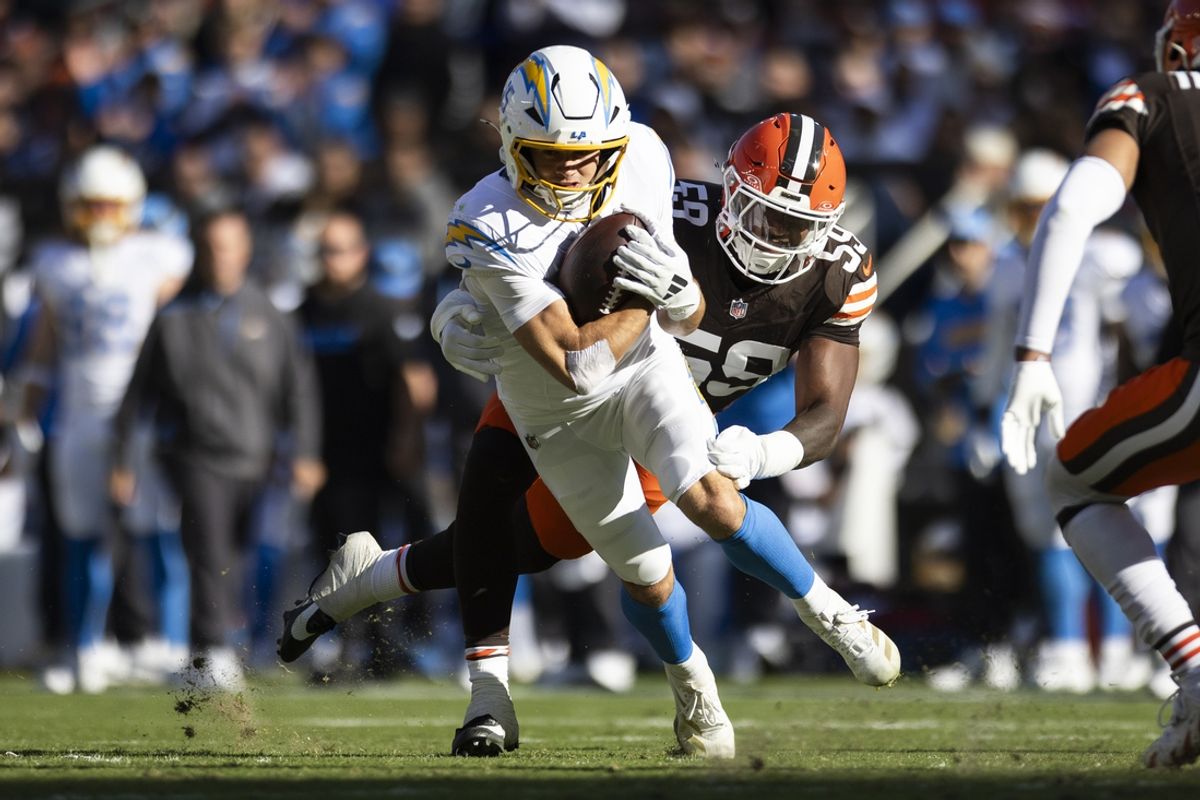 Nov 3, 2024; Cleveland, Ohio, USA; Los Angeles Chargers wide receiver Ladd McConkey (15) runs the ball as Cleveland Browns linebacker Winston Reid (59) tackles him during the second quarter at Huntington Bank Field. Mandatory Credit: Scott Galvin-Imagn Images