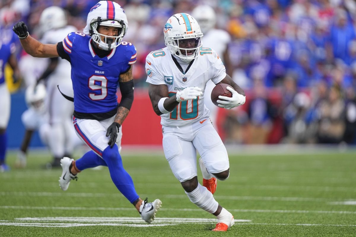 Nov 3, 2024; Orchard Park, New York, USA; Miami Dolphins wide receiver Tyreek Hill (10) runs with the ball against Buffalo Bills safety Taylor Rapp (9) during the second half at Highmark Stadium. Mandatory Credit: Gregory Fisher-Imagn Images