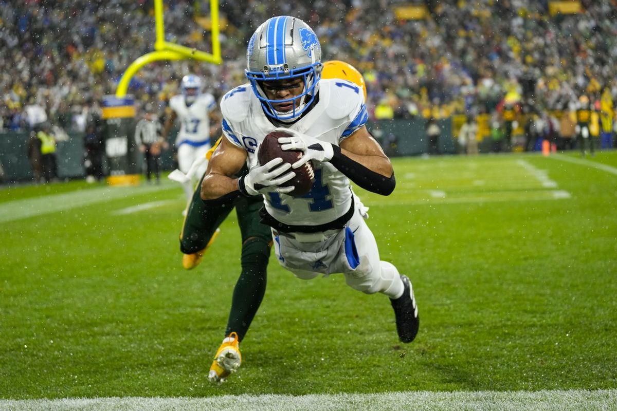 Nov 3, 2024; Green Bay, Wisconsin, USA;  Detroit Lions wide receiver Amon-Ra St. Brown (14) catches a pass in front of Green Bay Packers cornerback Keisean Nixon (25) to score a touchdown during the second quarter at Lambeau Field. Mandatory Credit: Jeff Hanisch-Imagn Images