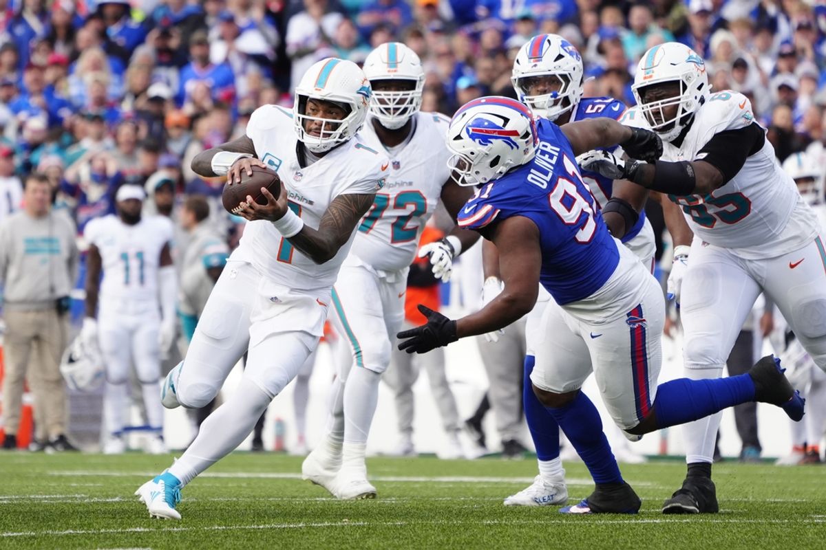 Nov 3, 2024; Orchard Park, New York, USA; Miami Dolphins quarterback Tua Tagovailoa (1) runs with the ball against Buffalo Bills defensive tackle Ed Oliver (91) during the second half at Highmark Stadium. Mandatory Credit: Gregory Fisher-Imagn Images