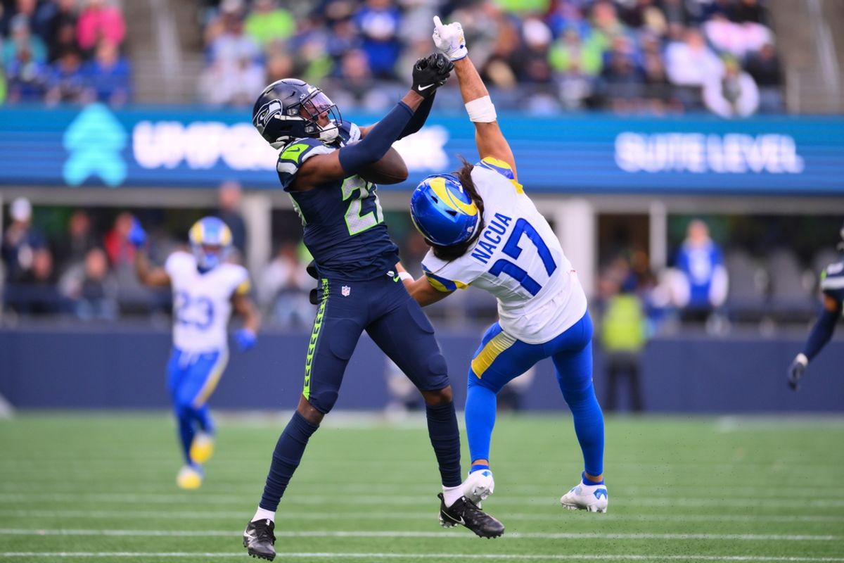 Nov 3, 2024; Seattle, Washington, USA; Seattle Seahawks cornerback Riq Woolen (27) intercepts a pass intended for Los Angeles Rams wide receiver Puka Nacua (17) during the first half at Lumen Field. Mandatory Credit: Steven Bisig-Imagn Images