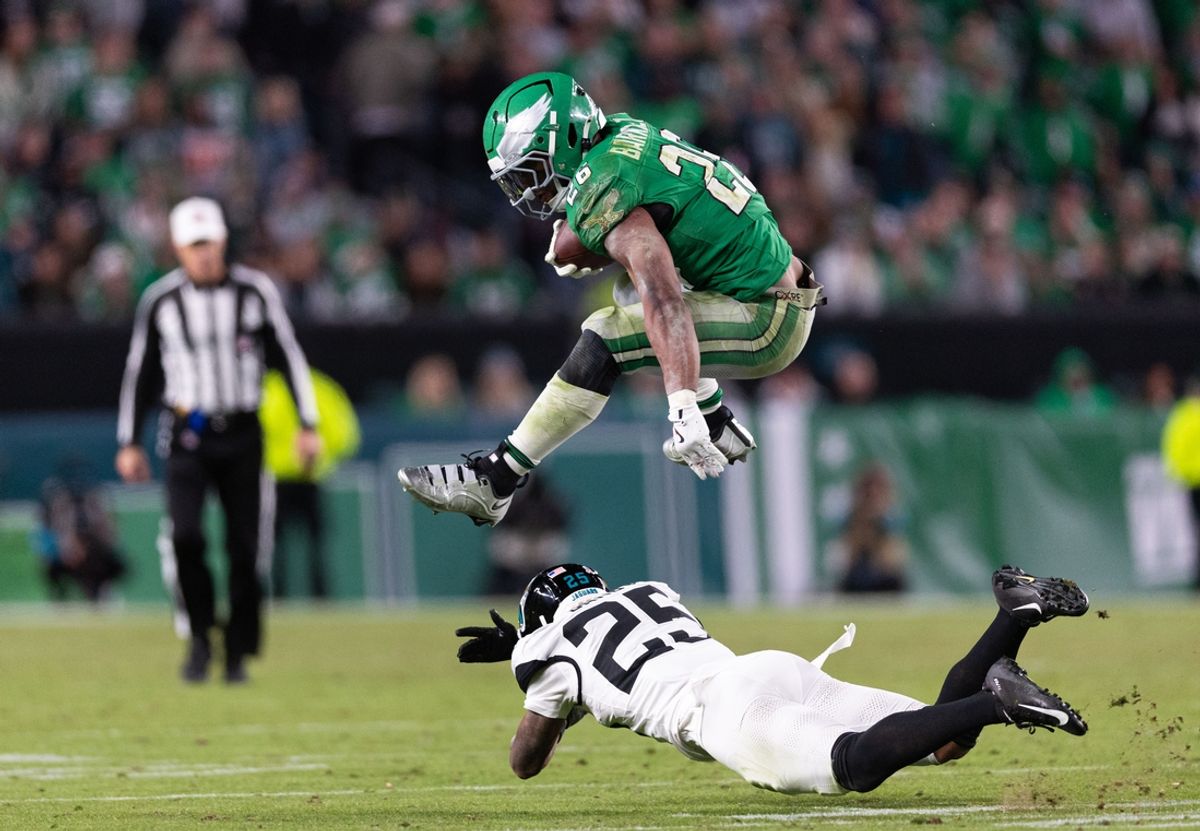 Nov 3, 2024; Philadelphia, Pennsylvania, USA; Philadelphia Eagles running back Saquon Barkley (26) leaps over Jacksonville Jaguars cornerback Ronald Darby (25) while running with the ball during the fourth quarter at Lincoln Financial Field. Mandatory Credit: Bill Streicher-Imagn Images