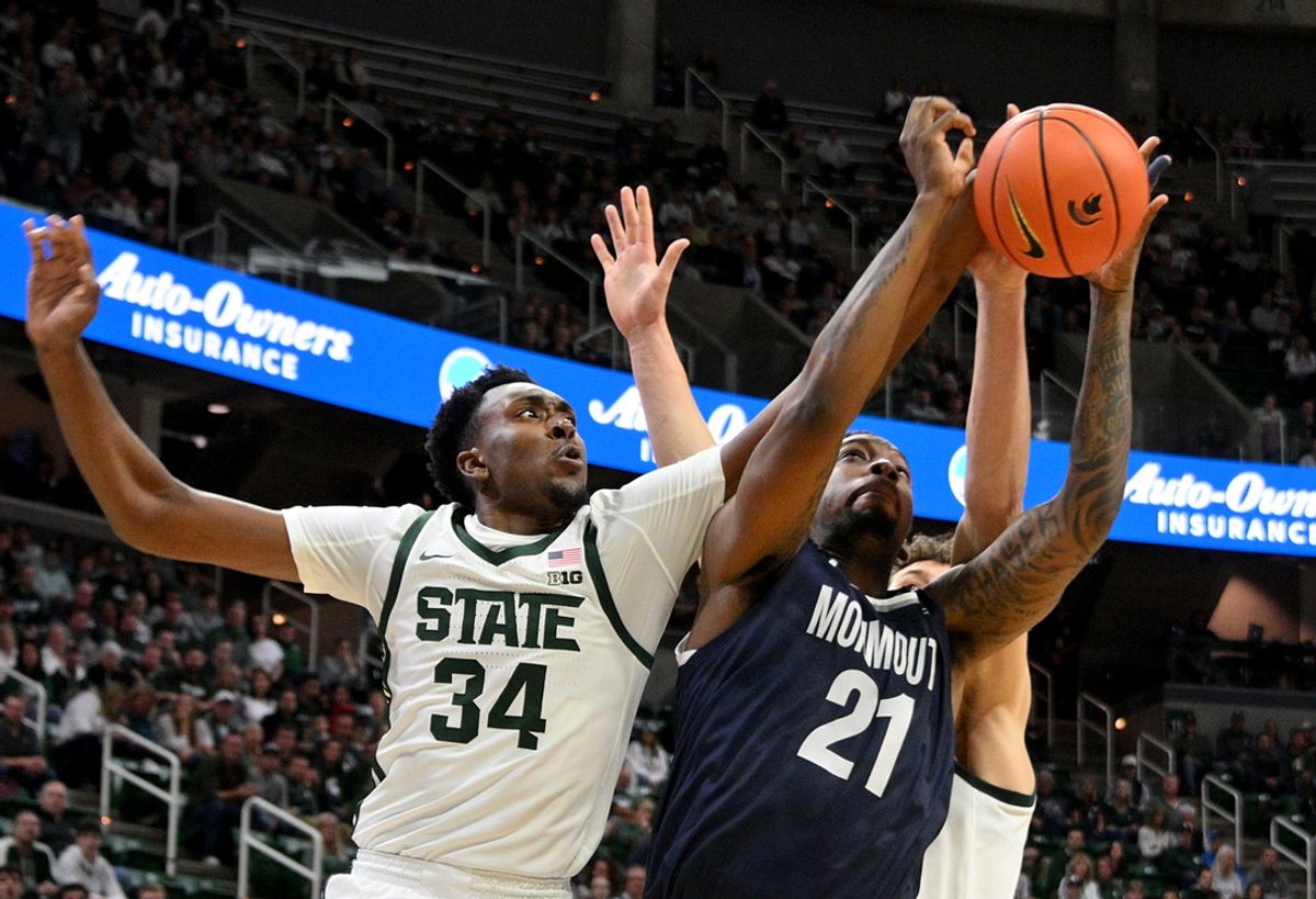 Nov 4, 2024; East Lansing, Michigan, USA; Michigan State Spartans forward Xavier Booker (34) defends Monmouth Hawks forward Chris Morgan (21) during the first half at Jack Breslin Student Events Center. Mandatory Credit: Dale Young-Imagn Images