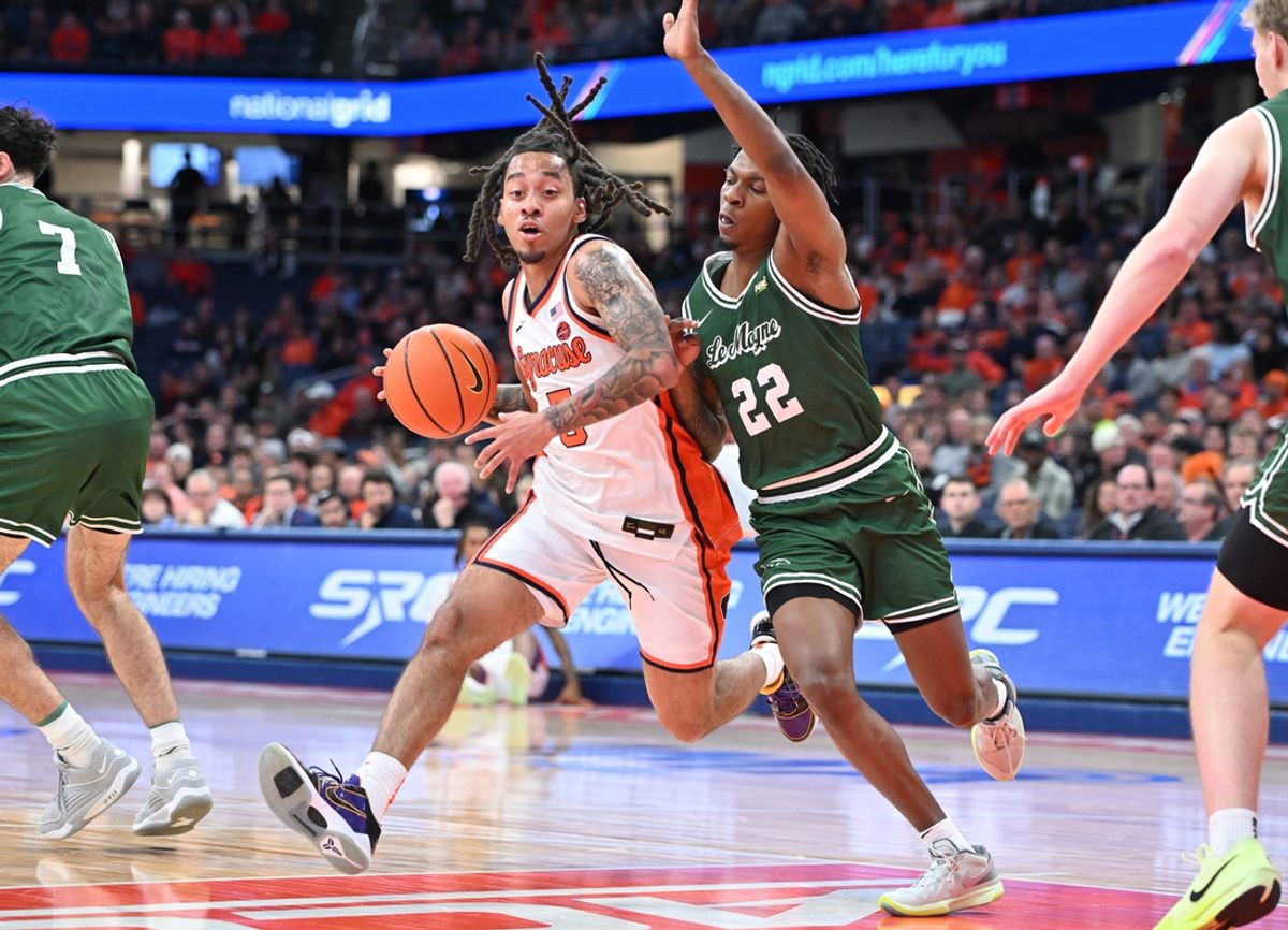 Nov 4, 2024; Syracuse, New York, USA; Syracuse Orange guard Jaquan Carlos (5) tries to get the ball past Le Moyne Dolphins guard Will Amica (22) in the first half at the JMA Wireless Dome. Mandatory Credit: Mark Konezny-Imagn Images