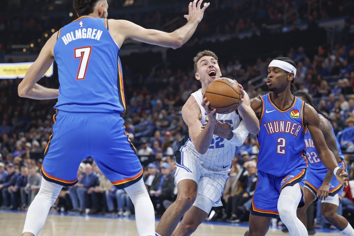 Nov 4, 2024; Oklahoma City, Oklahoma, USA; Orlando Magic forward Franz Wagner (22) drives to the basket between Oklahoma City Thunder forward Chet Holmgren (7) and guard Shai Gilgeous-Alexander (2) during the first quarter at Paycom Center. Mandatory Credit: Alonzo Adams-Imagn Images