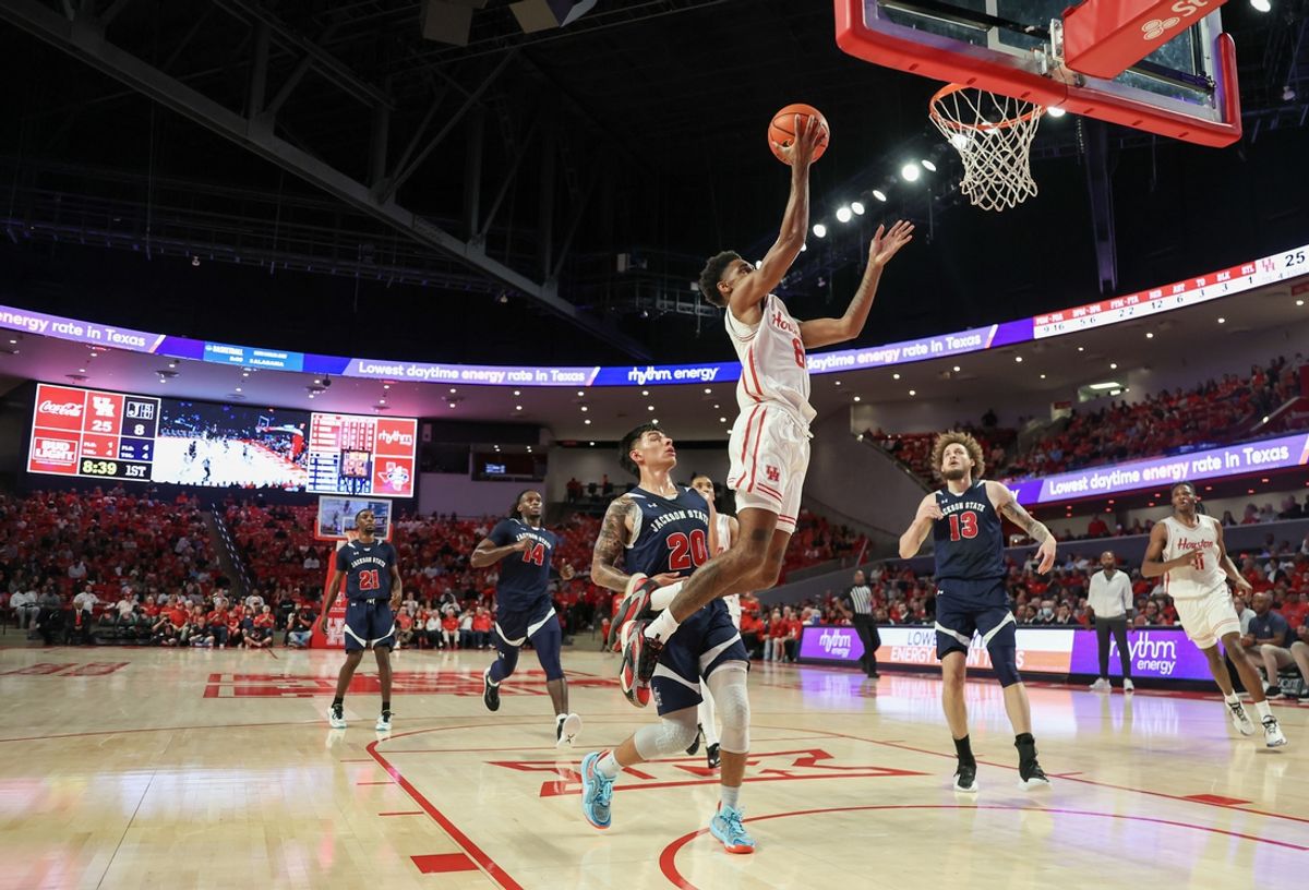 Nov 4, 2024; Houston, Texas, USA;  Houston Cougars guard Mylik Wilson (8) scores against Jackson State Tigers guard Juan Reyna III (20) in the first half at Fertitta Center. Mandatory Credit: Thomas B. Shea-Imagn Images