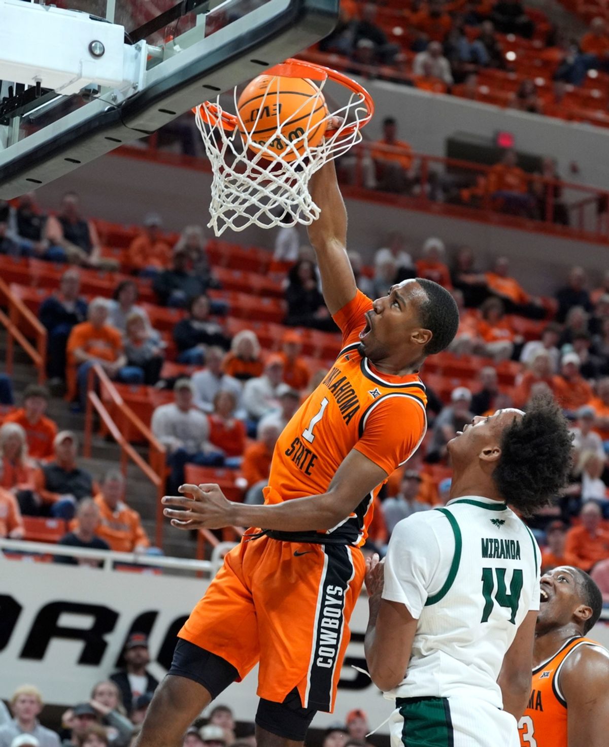 Oklahoma State Cowboys guard Bryce Thompson (1) dunks over Green Bay Phoenix center Isaiah Miranda (14) during a college basketball game between the Oklahoma State Cowboys (OSU) and the Green Bay Phoenix at Gallagher-Iba Arena in Stillwater, Okla., Monday, Nov. 4, 2024.