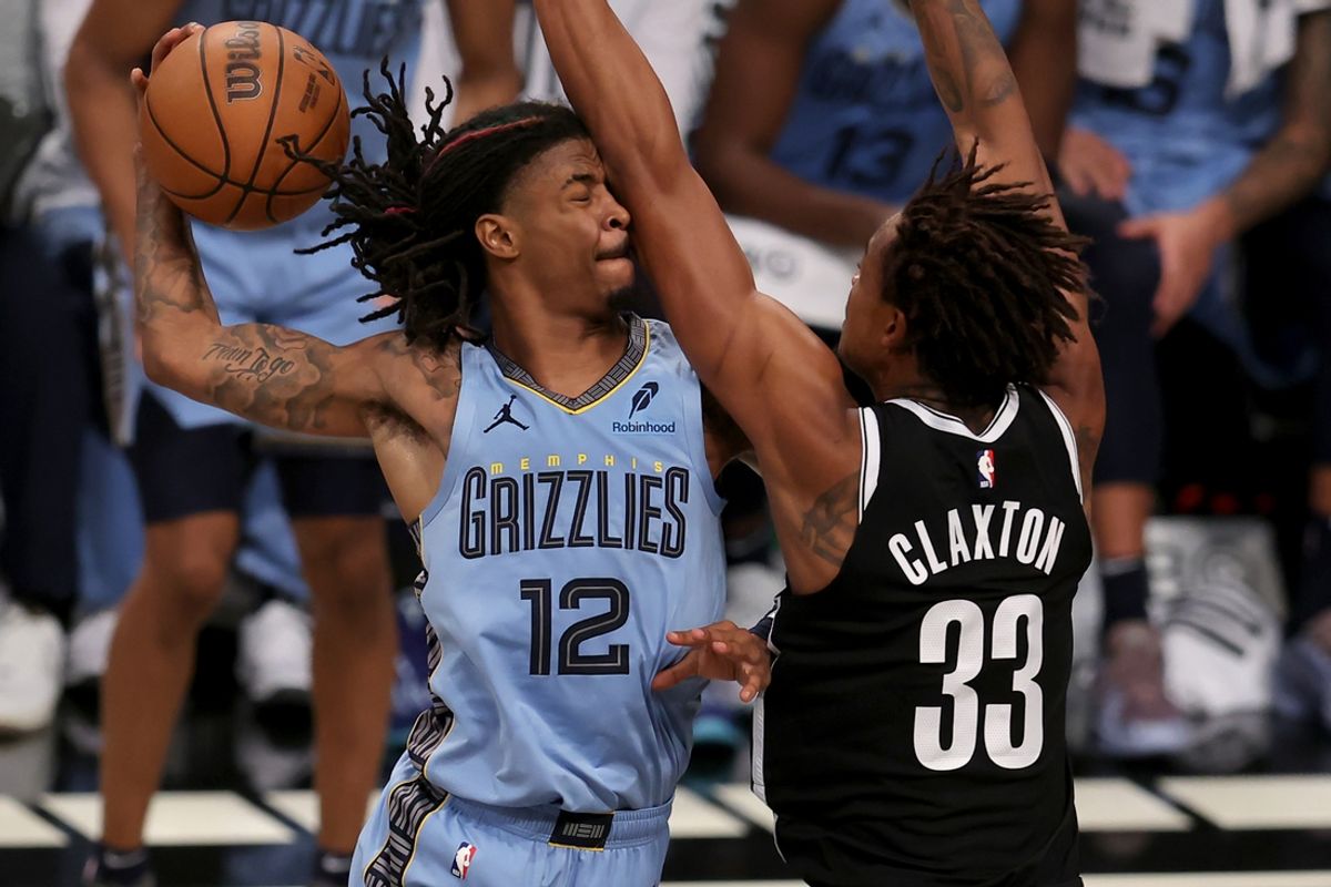 Nov 4, 2024; Brooklyn, New York, USA; Memphis Grizzlies guard Ja Morant (12) drives to the basket against Brooklyn Nets center Nic Claxton (33) during the fourth quarter at Barclays Center. Mandatory Credit: Brad Penner-Imagn Images