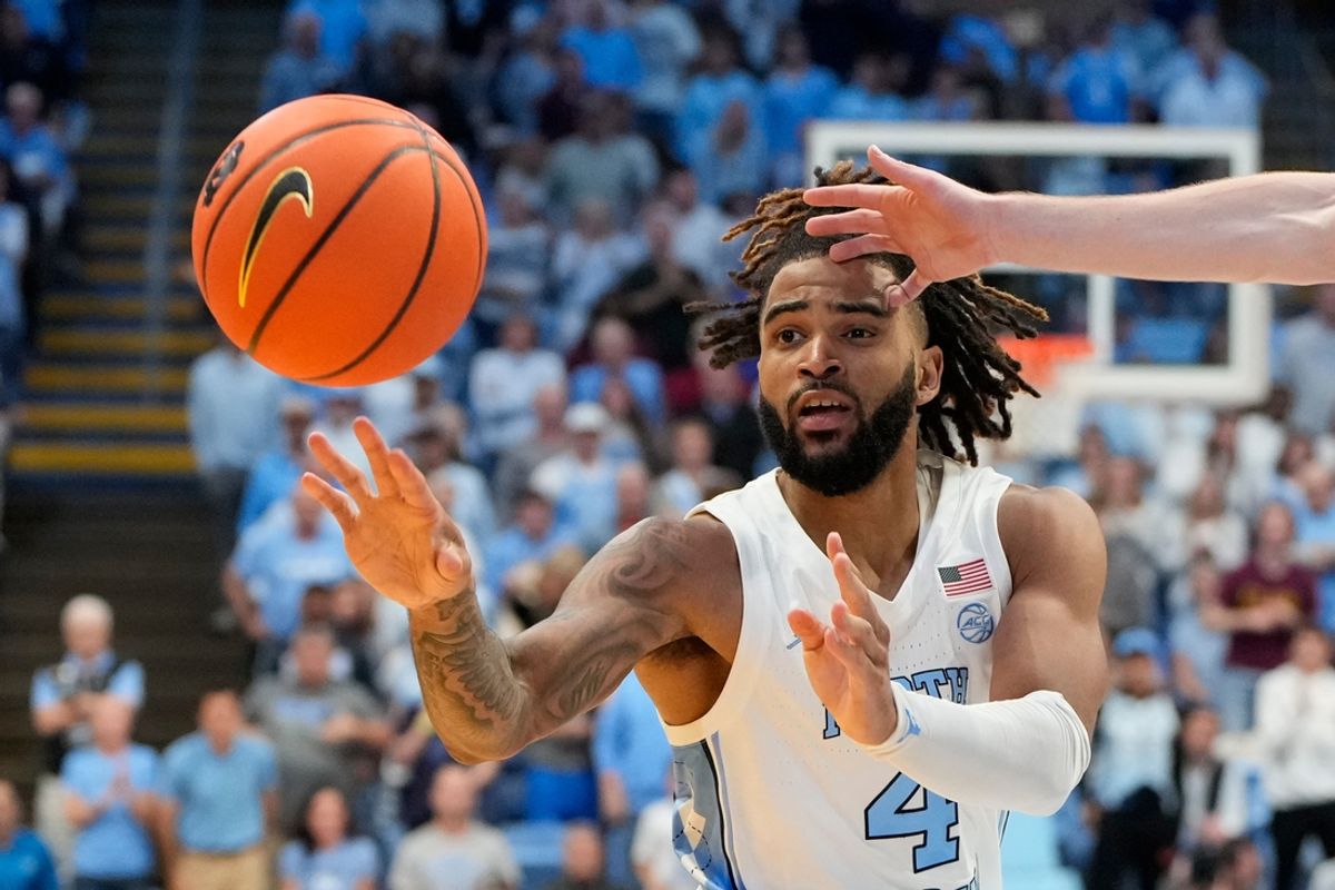 Nov 4, 2024; Chapel Hill, North Carolina, USA;  North Carolina Tar Heels guard RJ Davis (4) passes the ball as Elon Phoenix forward Isaac Harrell (12) defends in the second half at Dean E. Smith Center. Mandatory Credit: Bob Donnan-Imagn Images