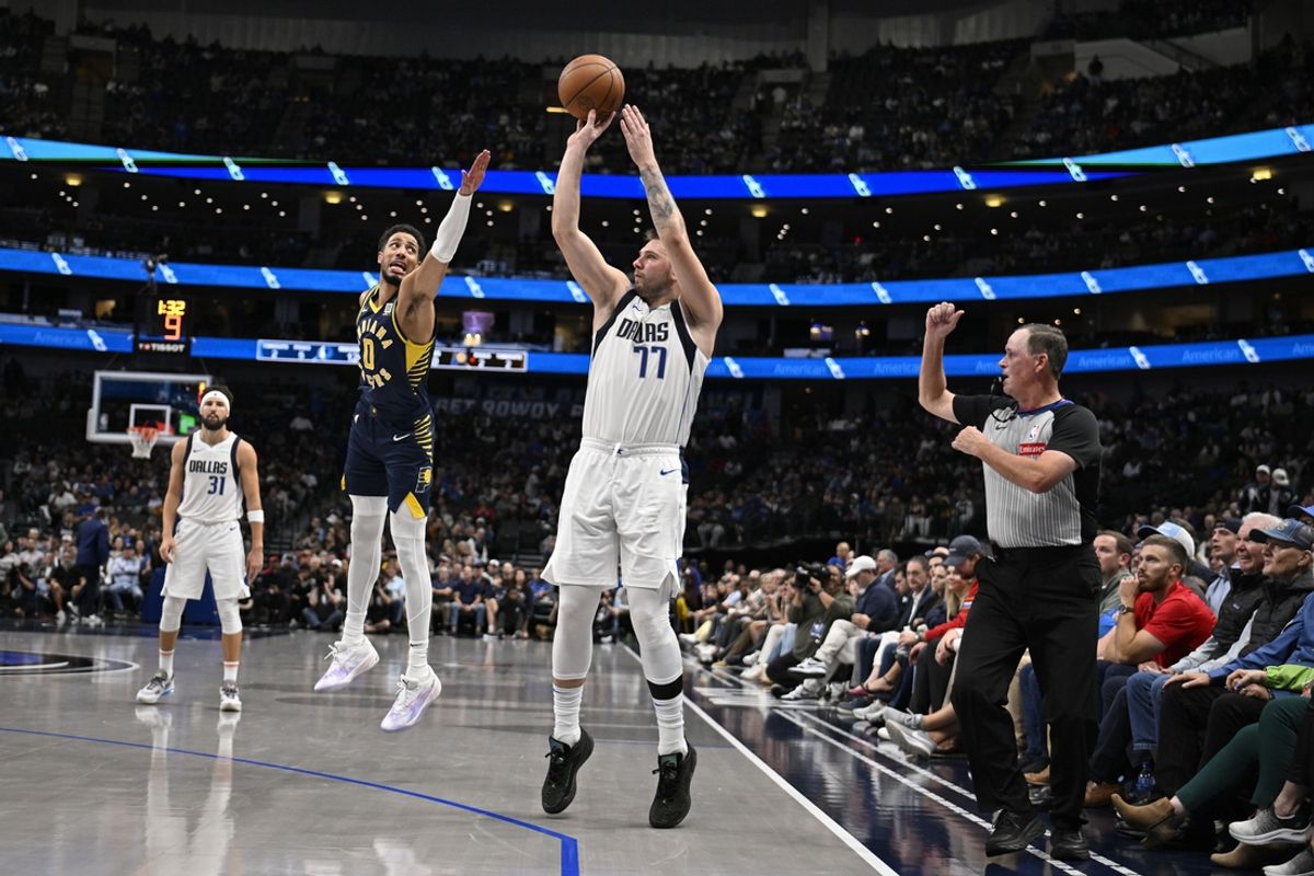 Nov 4, 2024; Dallas, Texas, USA; Dallas Mavericks guard Luka Doncic (77) makes a three point shot over Indiana Pacers guard Tyrese Haliburton (0) during the second half at the American Airlines Center. Mandatory Credit: Jerome Miron-Imagn Images