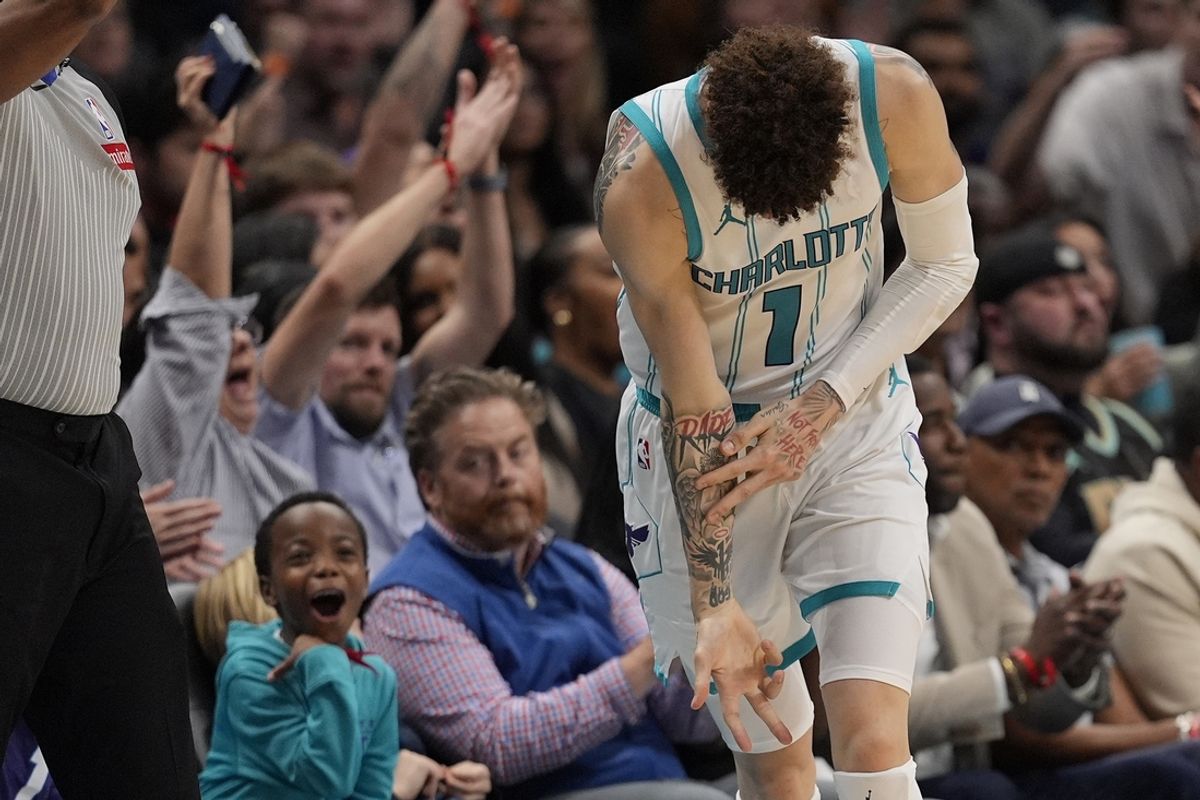 Nov 6, 2024; Charlotte, North Carolina, USA; Charlotte Hornets guard LaMelo Ball (1)  and a young fan react to his three point shot during the second quarter against the Detroit Pistons at Spectrum Center. Mandatory Credit: Jim Dedmon-Imagn Images