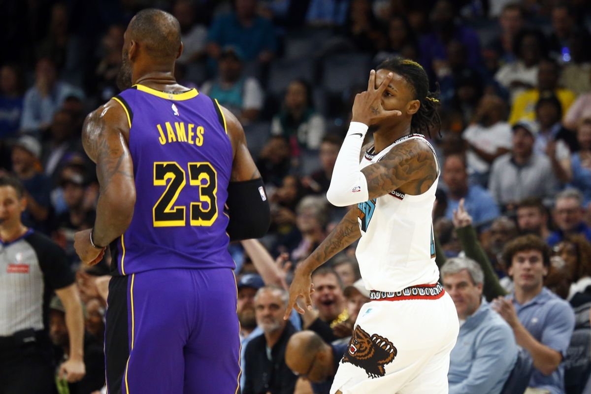Nov 6, 2024; Memphis, Tennessee, USA; Memphis Grizzlies guard Ja Morant (12) reacts toward Los Angeles Lakers forward LeBron James (23) after a three point basket during the first half at FedExForum. Mandatory Credit: Petre Thomas-Imagn Images
