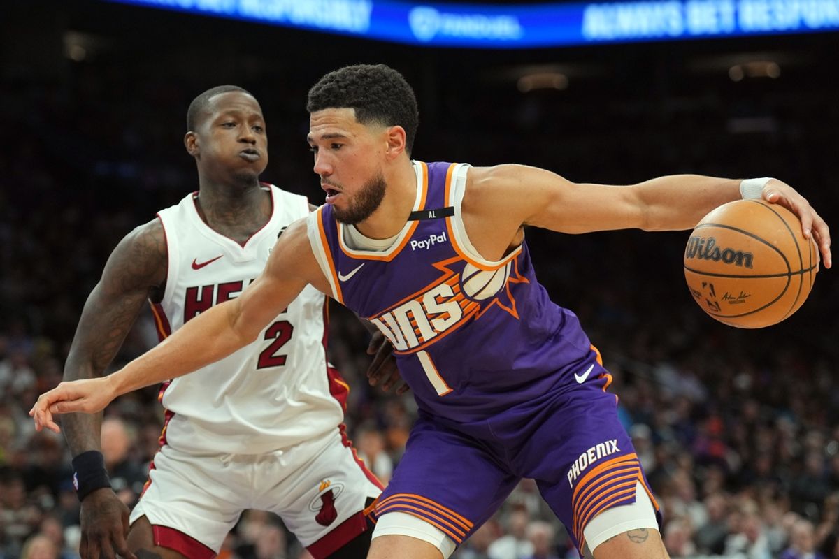 Nov 6, 2024; Phoenix, Arizona, USA; Phoenix Suns guard Devin Booker (1) dribbles against Miami Heat guard Terry Rozier (2) during the first half at Footprint Center. Mandatory Credit: Joe Camporeale-Imagn Images