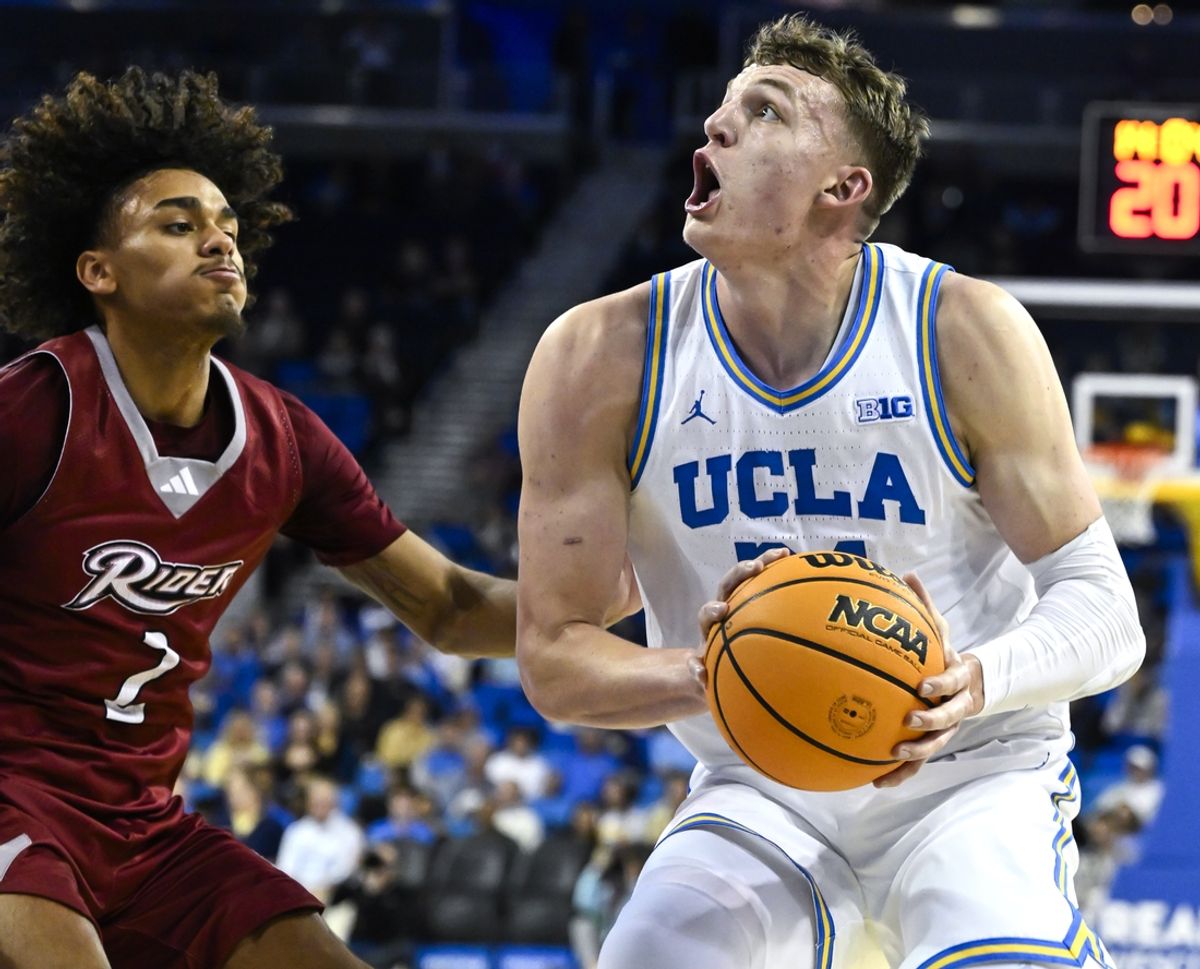 Nov 4, 2024; Los Angeles, California, USA; UCLA Bruins forward Tyler Bilodeau (34) drives to the basket as Rider Broncs guard Ruben Rodriguez (2) during the first half at Pauley Pavilion presented by Wescom. Mandatory Credit: Robert Hanashiro-Imagn Images