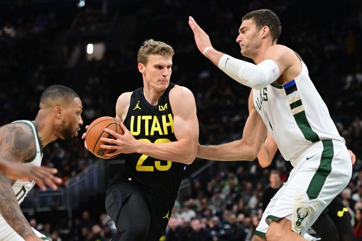 Nov 7, 2024; Milwaukee, Wisconsin, USA; Utah Jazz forward Lauri Markkanen (23) drives for the basket between Milwaukee Bucks guard Damian Lillard (0) and center Brook Lopez (11) in the first quarter at Fiserv Forum. Mandatory Credit: Benny Sieu-Imagn Images