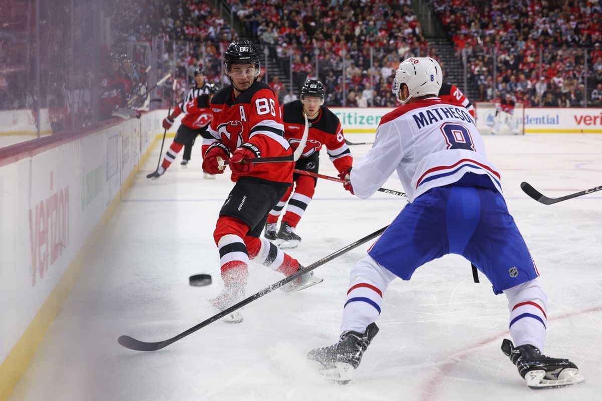 Nov 7, 2024; Newark, New Jersey, USA; New Jersey Devils center Jack Hughes (86) plays the puck while being defended by Montreal Canadiens defenseman Mike Matheson (8) during the second period at Prudential Center. Mandatory Credit: Ed Mulholland-Imagn Images