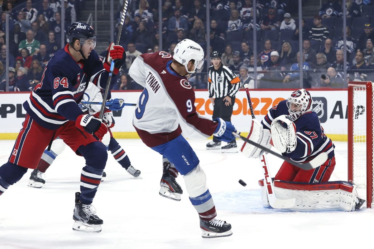 Nov 7, 2024; Winnipeg, Manitoba, CAN; Winnipeg Jets goaltender Connor Hellebuyck (37) stops a shot by Colorado Avalanche center T.J. Tynan (9) in the first period at Canada Life Centre. Mandatory Credit: James Carey Lauder-Imagn Images