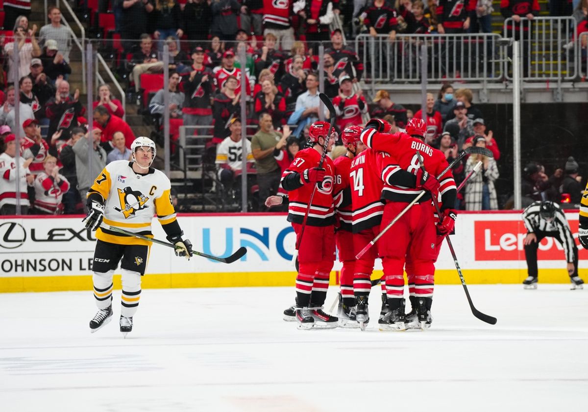 Nov 7, 2024; Raleigh, North Carolina, USA;  Carolina Hurricanes defenseman Jaccob Slavin (74) is congratulated by defenseman Brent Burns (8) and  right wing Andrei Svechnikov (37) after his goal against the Pittsburgh Penguins during the second period at Lenovo Center. Mandatory Credit: James Guillory-Imagn Images