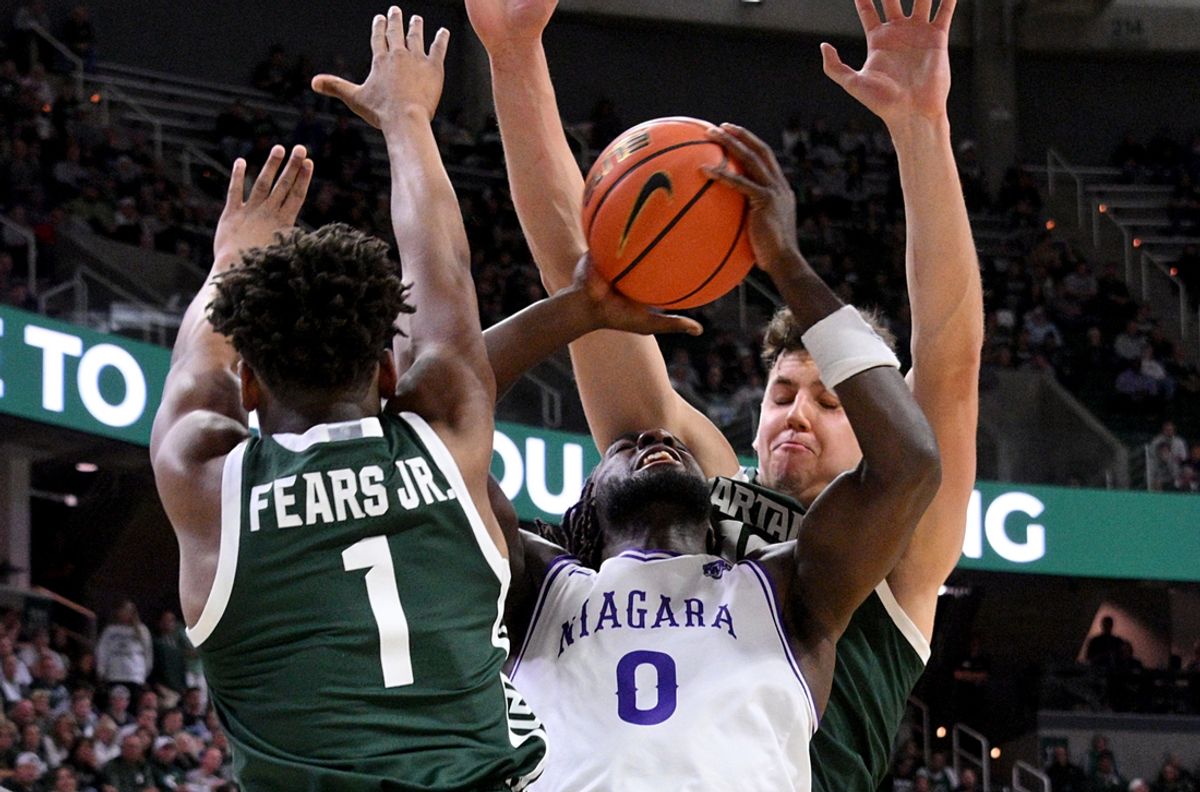 Nov 7, 2024; East Lansing, Michigan, USA;  Niagara Purple Eagles forward Olumide Adelodun (0) gets trapped under the basket by Michigan State Spartans defenders during the first half at Jack Breslin Student Events Center. Mandatory Credit: Dale Young-Imagn Images