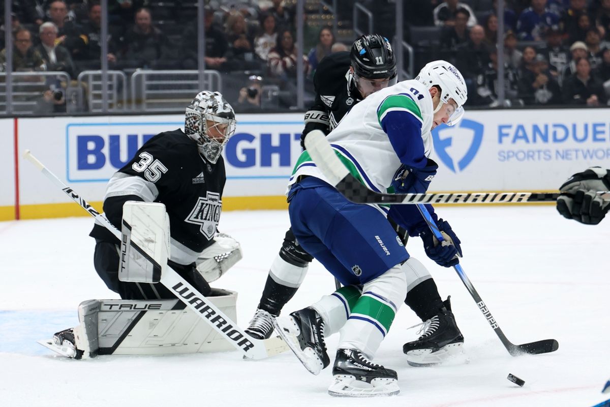 Nov 7, 2024; Los Angeles, California, USA;  Vancouver Canucks left wing Nils Hoglander (21) fights for the puck against Los Angeles Kings center Anze Kopitar (11) during the first period at Crypto.com Arena. Mandatory Credit: Kiyoshi Mio-Imagn Images