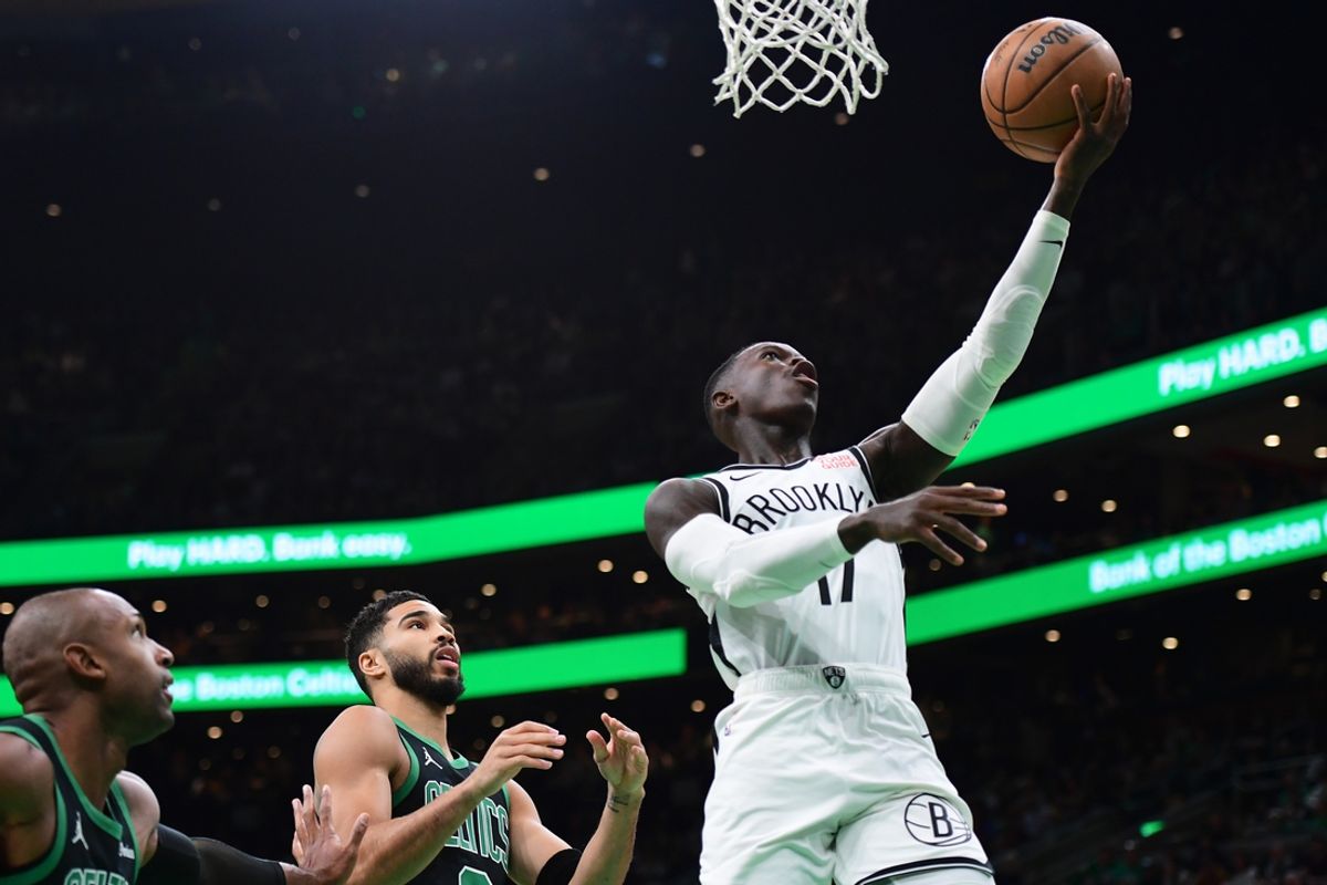 Nov 8, 2024; Boston, Massachusetts, USA;  Brooklyn Nets guard Dennis Schroder (17) lays the ball in the basket past Boston Celtics forward Jayson Tatum (0) during the first half at TD Garden. Mandatory Credit: Bob DeChiara-Imagn Images