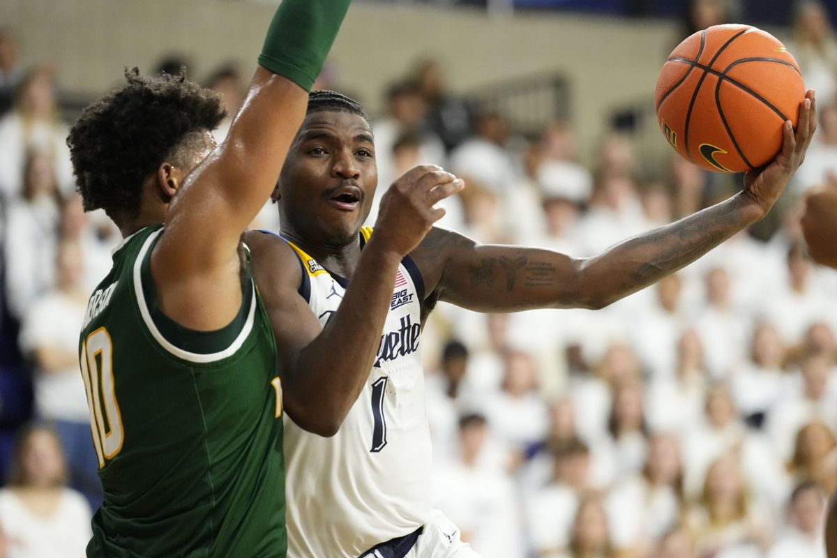 Nov 8, 2024; Milwaukee, Wisconsin, USA;  Marquette Golden Eagles guard Kam Jones (1) shoots against George Mason Patriots forward Zach Anderson (10) during the first half at the Al McGuire Center. Mandatory Credit: Jeff Hanisch-Imagn Images
