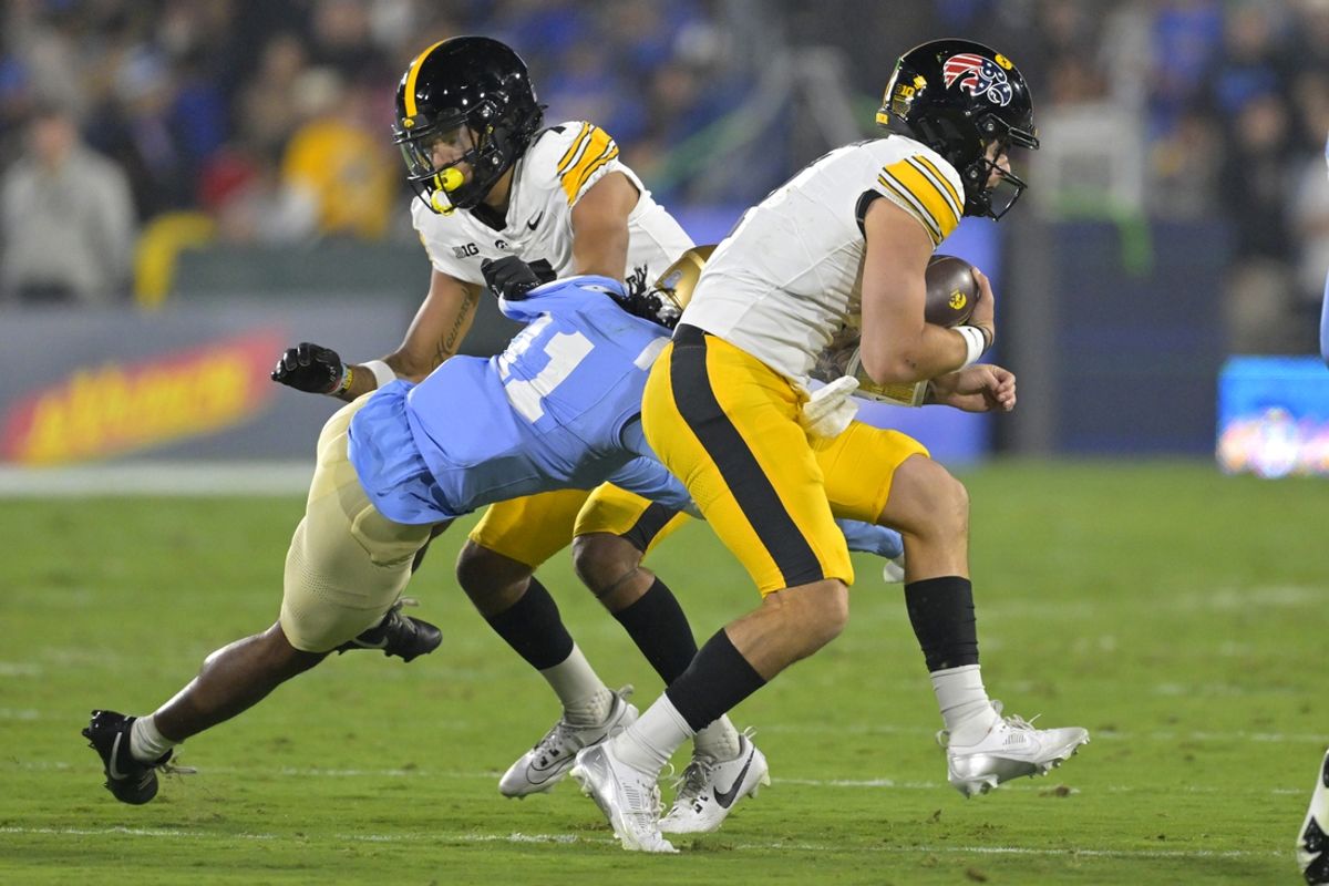 Nov 8, 2024; Pasadena, California, USA;    UCLA Bruins defensive back Ramon Henderson (11) chases down Iowa Hawkeyes quarterback Brendan Sullivan (1) in the first half at the Rose Bowl. Mandatory Credit: Jayne Kamin-Oncea-Imagn Images