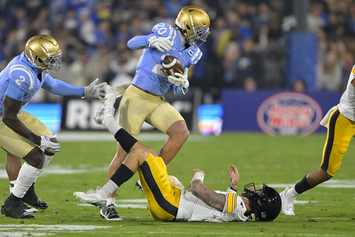 Nov 8, 2024; Pasadena, California, USA;   UCLA Bruins linebacker Kain Medrano (20) strips the ball from Iowa Hawkeyes quarterback Brendan Sullivan (1) giving the Bruins possession in the first half at the Rose Bowl. Mandatory Credit: Jayne Kamin-Oncea-Imagn Images