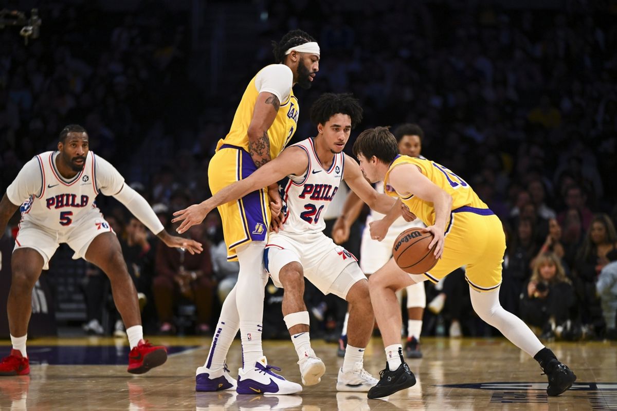 Nov 8, 2024; Los Angeles, California, USA; Los Angeles Lakers guard Austin Reaves (15) dribbles against Philadelphia 76ers guard Jared McCain (20) during the first half at Crypto.com Arena. Mandatory Credit: Jonathan Hui-Imagn Images