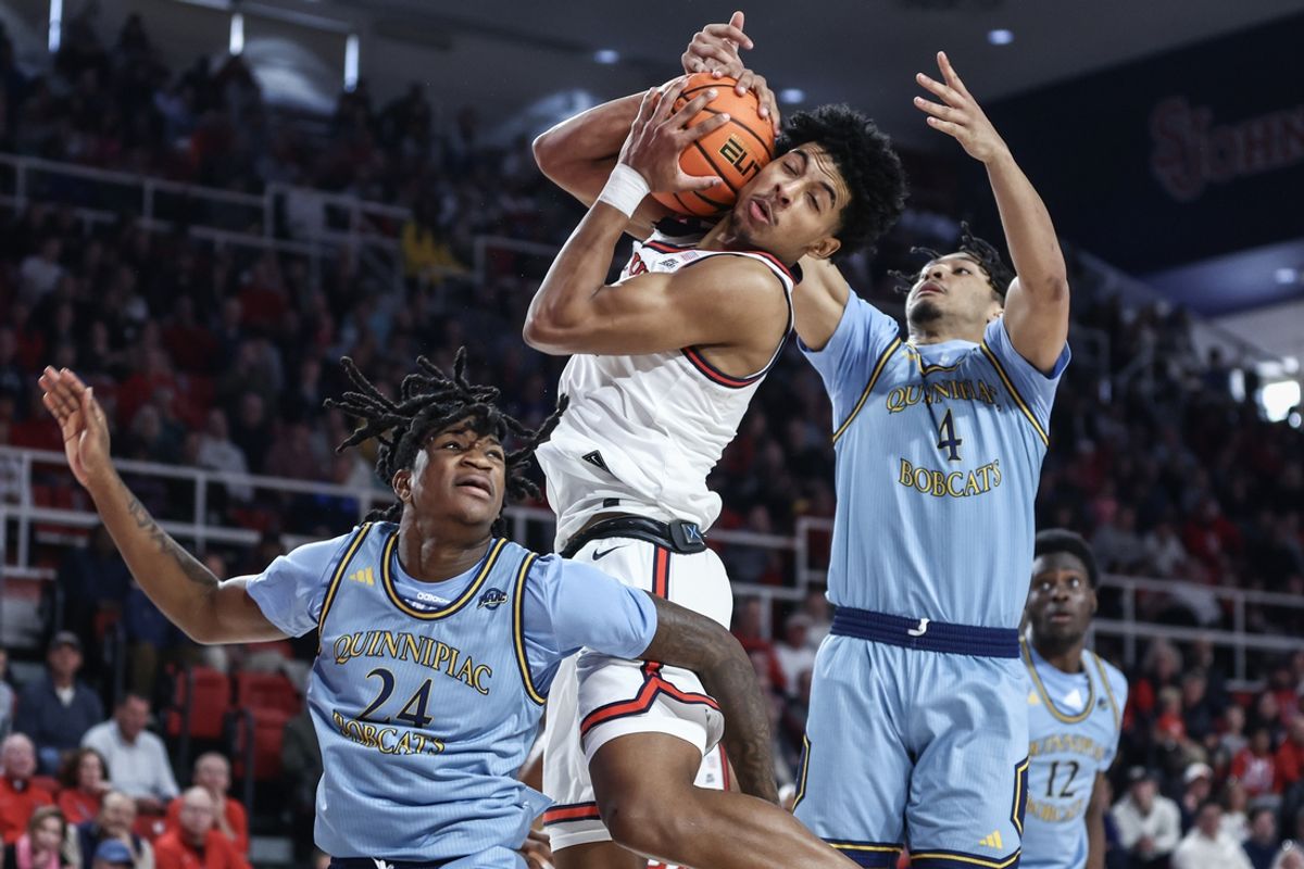 Nov 9, 2024; Queens, New York, USA;  St. John's Red Storm guard RJ Luis Jr. (12) jumps in between Quinnipiac Bobcats guards Jaden Zimmerman (24) and Khaden Bennett (4) to grab a rebound in the first half at Carnesecca Arena. Mandatory Credit: Wendell Cruz-Imagn Images