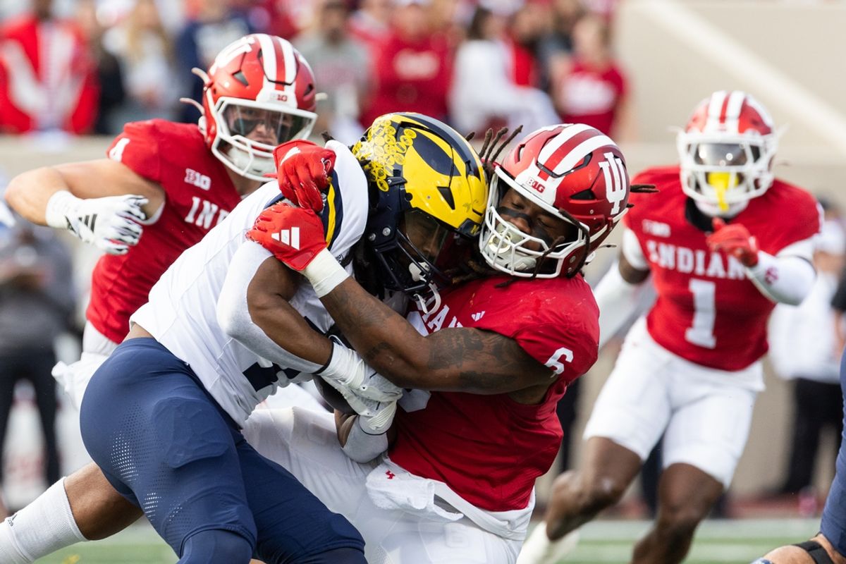 Nov 9, 2024; Bloomington, Indiana, USA;  Michigan Wolverines running back Donovan Edwards (7) runs with the ball while Indiana Hoosiers defensive lineman Mikail Kamara (6) defends in the first quarter at Memorial Stadium. Mandatory Credit: Trevor Ruszkowski-Imagn Images