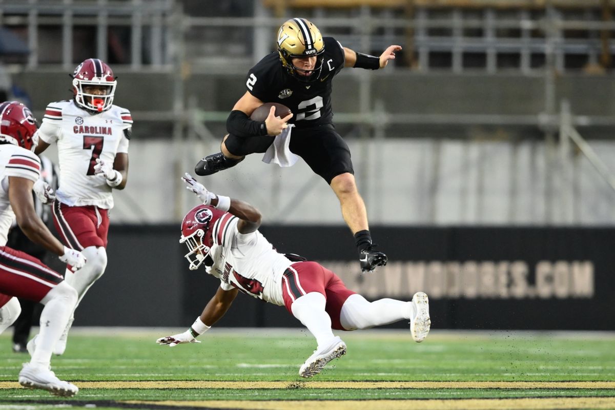 Nov 9, 2024; Nashville, Tennessee, USA;  Vanderbilt Commodores quarterback Diego Pavia (2) hurdles over South Carolina Gamecocks linebacker Jaron Willis (14) during the first half at FirstBank Stadium. Mandatory Credit: Steve Roberts-Imagn Images