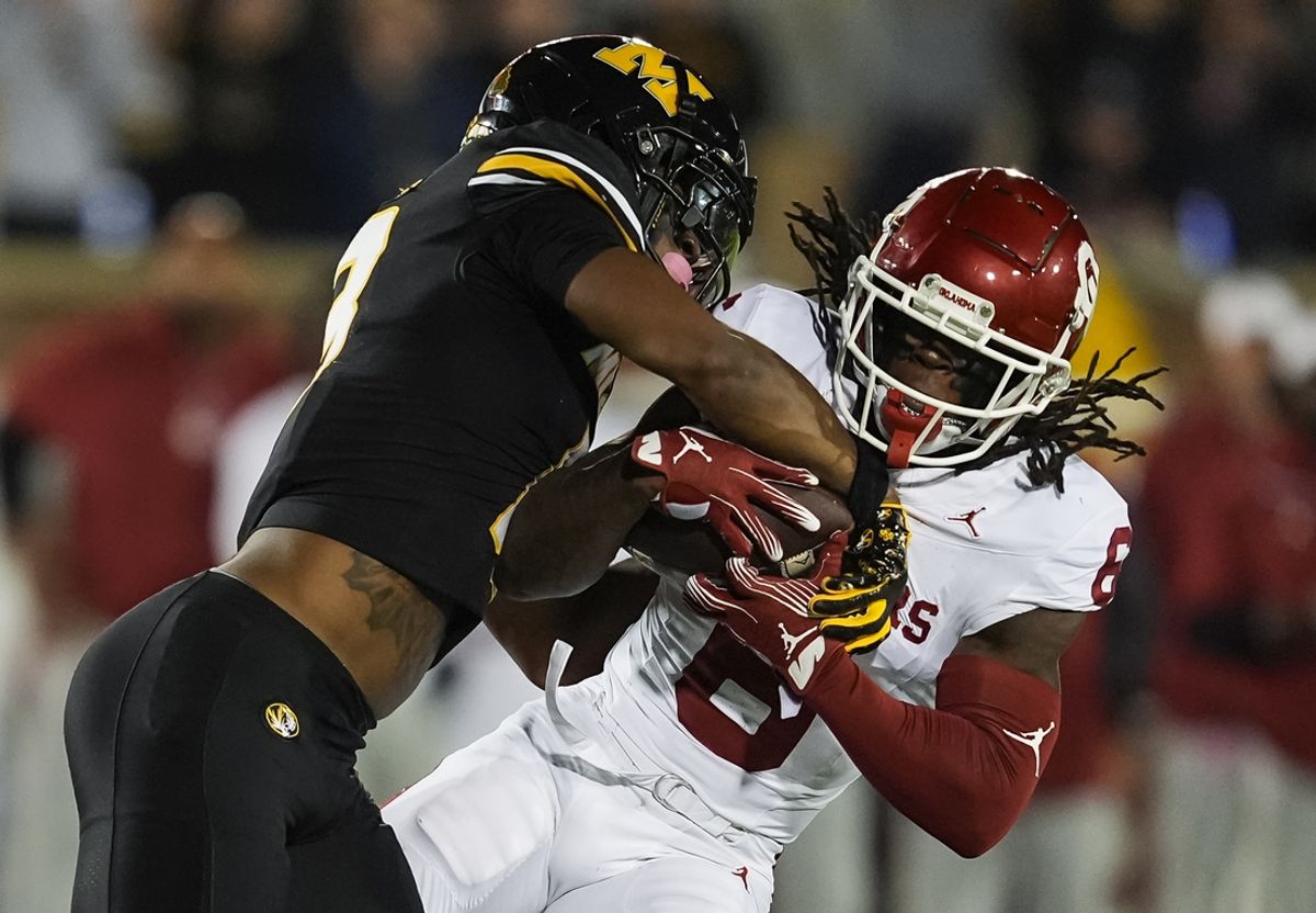 Nov 9, 2024; Columbia, Missouri, USA; Oklahoma Sooners wide receiver Deion Burks (6) is tackled by Missouri Tigers safety Daylan Carnell (13) during the first half at Faurot Field at Memorial Stadium. Mandatory Credit: Jay Biggerstaff-Imagn Images