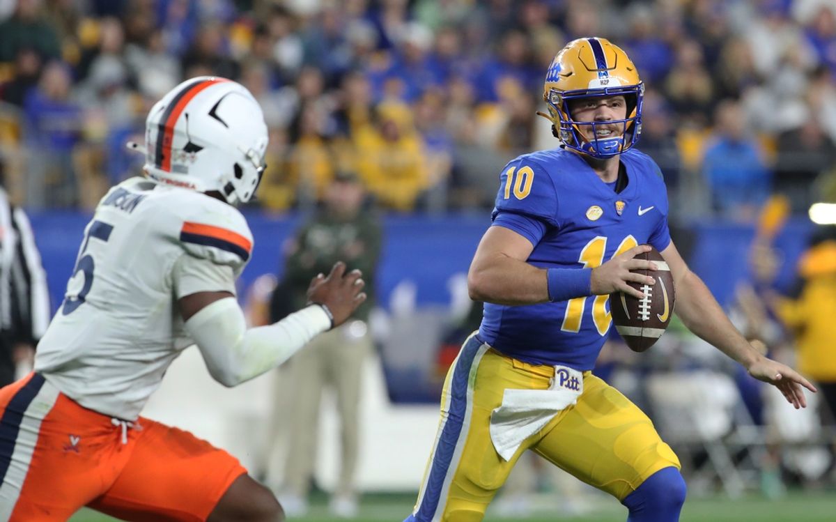 Nov 9, 2024; Pittsburgh, Pennsylvania, USA;  Pittsburgh Panthers quarterback Eli Holstein (10) scrambles with the ball as Virginia Cavaliers linebacker Kam Robinson (5) chases during the second quarter at Acrisure Stadium. Mandatory Credit: Charles LeClaire-Imagn Images
