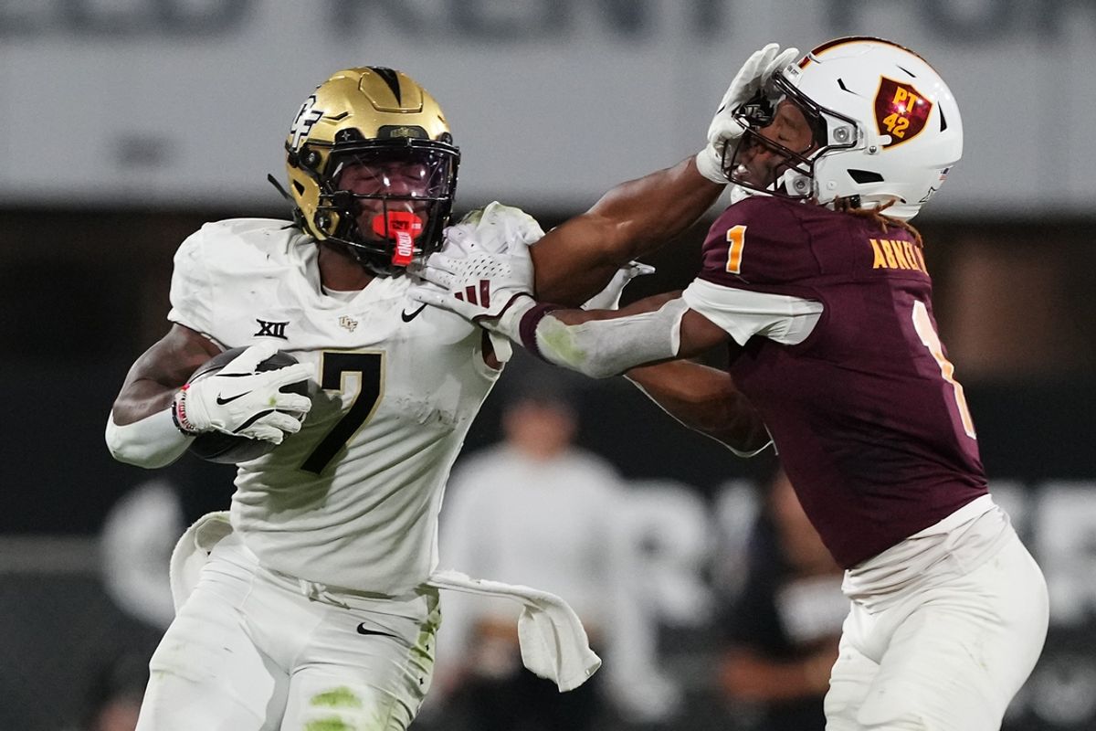 Nov 9, 2024; Tempe, Arizona, USA; UCF Knights running back RJ Harvey (7) delivers a stiff arm to Arizona State Sun Devils defensive back Keith Abney II (1) during the second half at Mountain America Stadium, Home of the ASU Sun Devils. Mandatory Credit: Joe Camporeale-Imagn Images