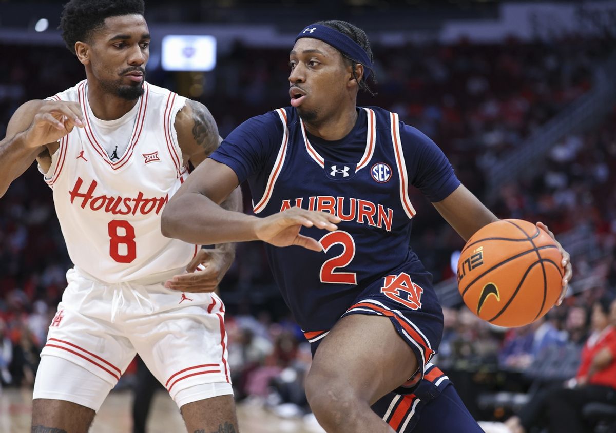 Nov 9, 2024; Houston, Texas, USA; Auburn Tigers guard Denver Jones (2) drives with the ball as Houston Cougars guard Mylik Wilson (8) defends during the first half at Toyota Center. Mandatory Credit: Troy Taormina-Imagn Images