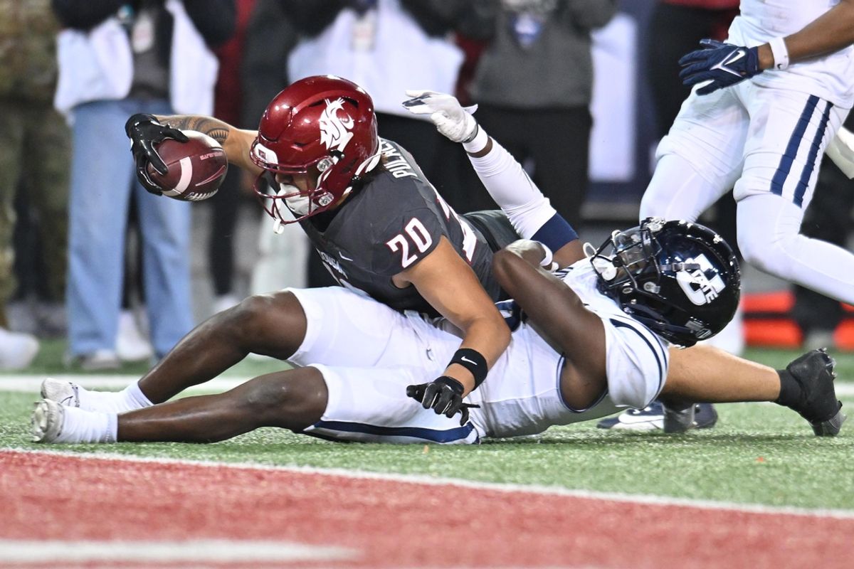 Nov 9, 2024; Pullman, Washington, USA; Washington State Cougars running back Leo Pulalasi (20) stretches for the goal line against Utah State Aggies safety Ike Larsen (6) in the second half at Gesa Field at Martin Stadium. Mandatory Credit: James Snook-Imagn Images