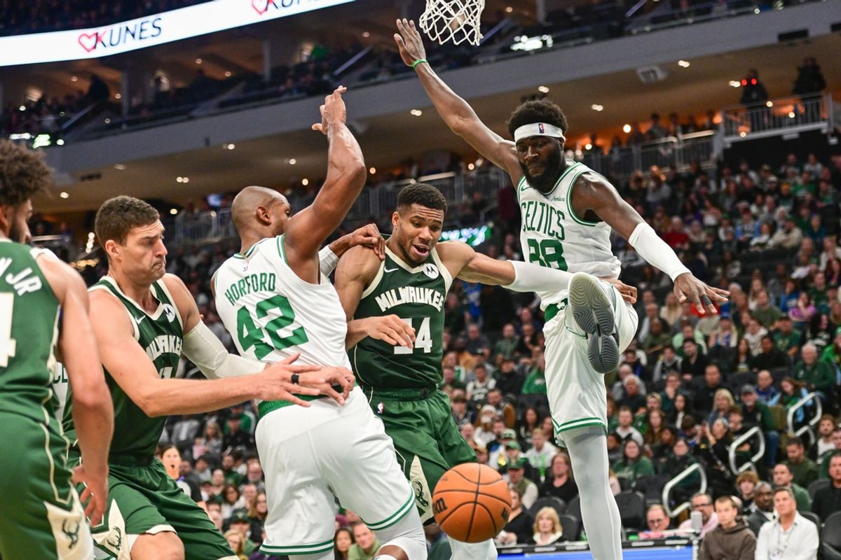 Nov 10, 2024; Milwaukee, Wisconsin, USA; Milwaukee Bucks forward Giannis Antetokounmpo (34) reaches for a rebound between Boston Celtics center Al Horford (42) and center Neemias Queta (88) in the second quarter at Fiserv Forum. Mandatory Credit: Benny Sieu-Imagn Images