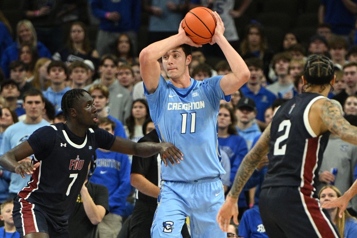 Nov 10, 2024; Omaha, Nebraska, USA;  Creighton Bluejays center Ryan Kalkbrenner (11) passes against Fairleigh Dickinson Knights forward Bismark Nsiah (7) during the first half at CHI Health Center Omaha. Mandatory Credit: Steven Branscombe-Imagn Images
