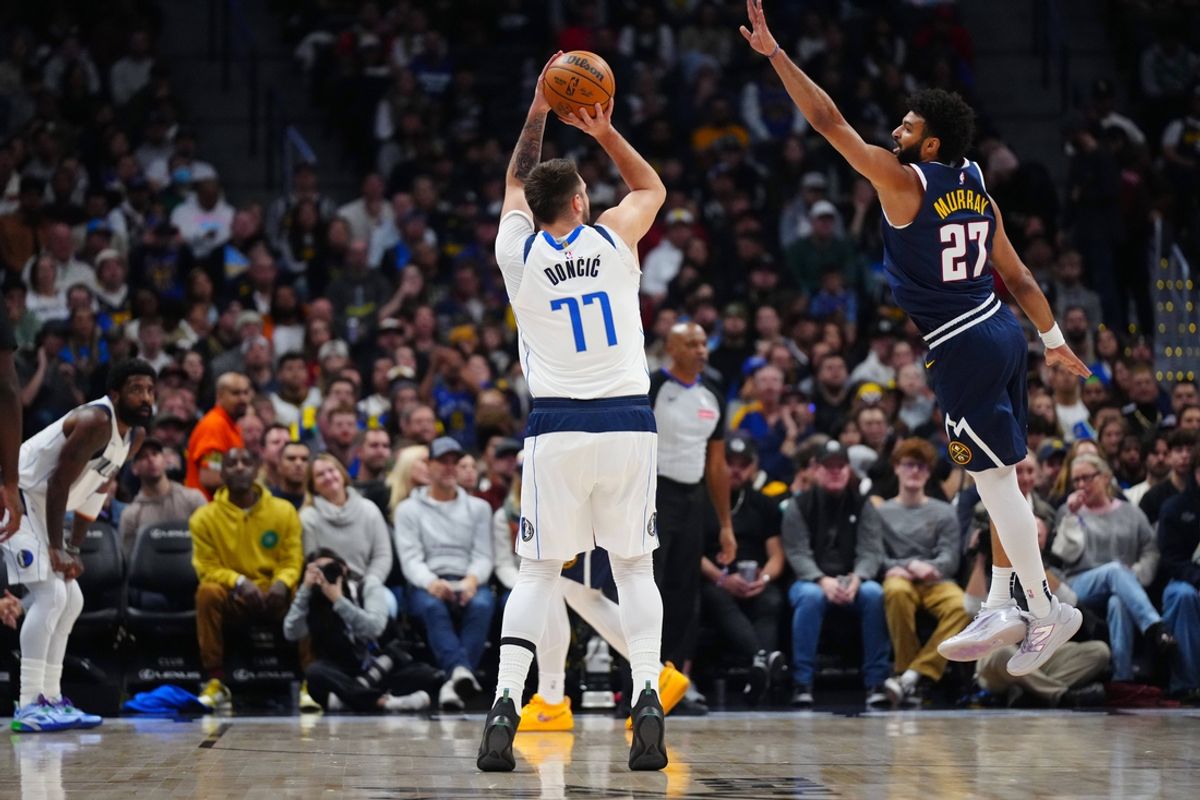 Nov 10, 2024; Denver, Colorado, USA; Dallas Mavericks guard Luka Doncic (77) prepares to shoot the ball at Denver Nuggets guard Jamal Murray (27) in the first quarter at Ball Arena. Mandatory Credit: Ron Chenoy-Imagn Images