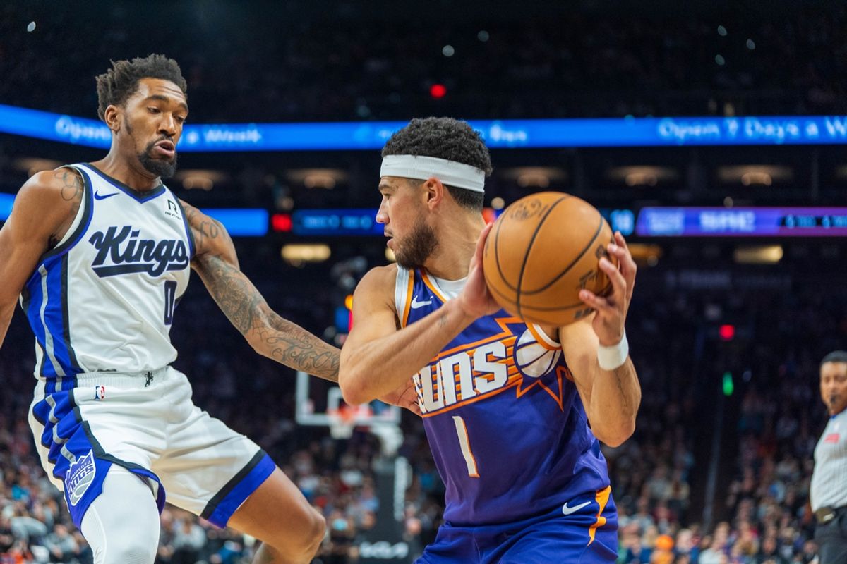 Nov 10, 2024; Phoenix, Arizona, USA; Phoenix Suns guard Devin Booker (1) reacts as Sacramento Kings guard Malik Monk (0) defends during a play in the first half during a game at Footprint Center. Mandatory Credit: Allan Henry-Imagn Images