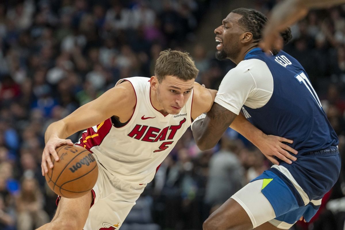 Nov 10, 2024; Minneapolis, Minnesota, USA; Miami Heat forward Nikola Jovic (5) drives to the basket past Minnesota Timberwolves center Naz Reid (11) in the second half at Target Center. Mandatory Credit: Jesse Johnson-Imagn Images