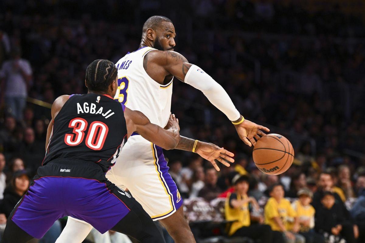 Nov 10, 2024; Los Angeles, California, USA; Los Angeles Lakers forward LeBron James (23) passes the ball against Toronto Raptors guard Ochai Agbaji (30) during the first half at Crypto.com Arena. Mandatory Credit: Jonathan Hui-Imagn Images