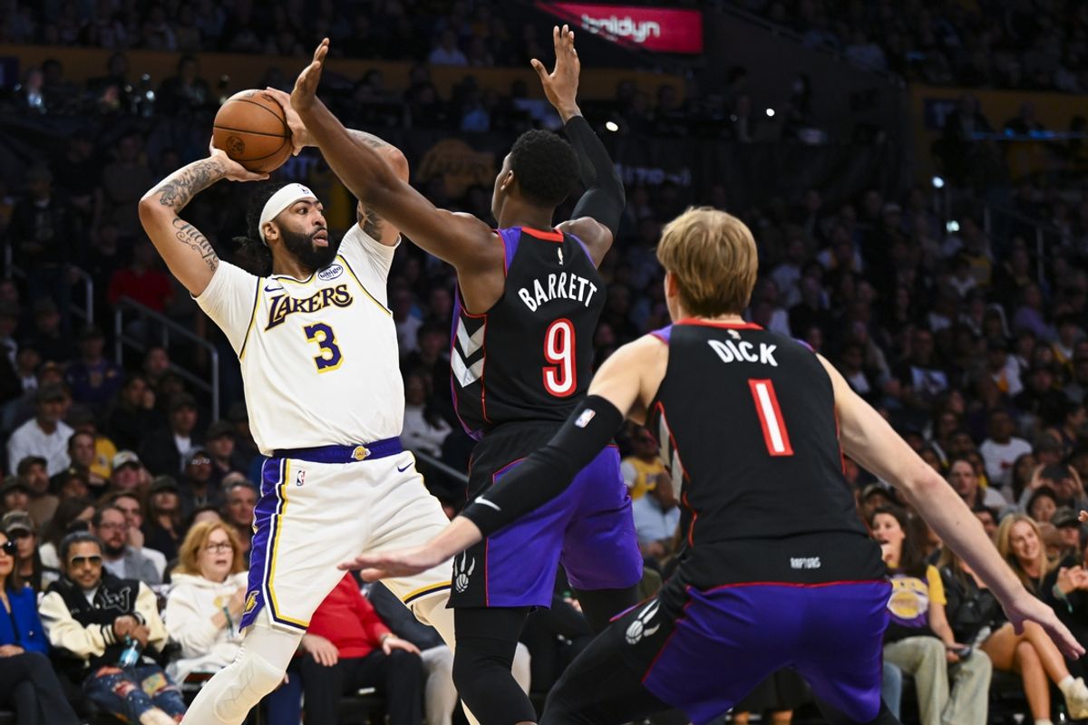 Nov 10, 2024; Los Angeles, California, USA; Los Angeles Lakers forward Anthony Davis (3) looks to pass against Toronto Raptors guard RJ Barrett (9) and guard Gradey Dick (1) during the first half at Crypto.com Arena. Mandatory Credit: Jonathan Hui-Imagn Images
