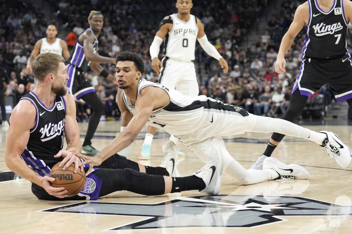 Nov 11, 2024; San Antonio, Texas, USA; Sacramento Kings center Domantas Sabonis (11) and San Antonio Spurs center Victor Wembanyama (1) battle for the loose ball during the first half at Frost Bank Center. Mandatory Credit: Scott Wachter-Imagn Images