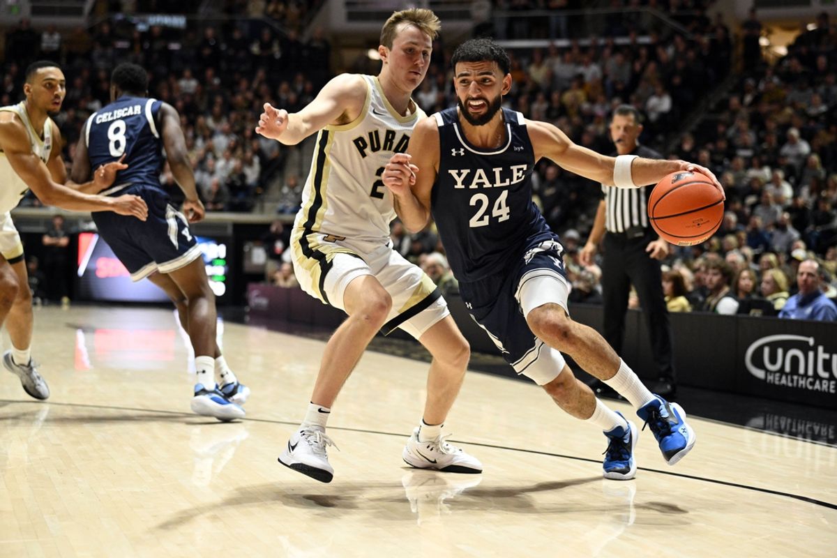 Nov 11, 2024; West Lafayette, Indiana, USA; Yale Bulldogs guard Yassine Gharram (24) drives the ball past Purdue Boilermakers guard Fletcher Loyer (2) during the first half at Mackey Arena. Mandatory Credit: Marc Lebryk-Imagn Images