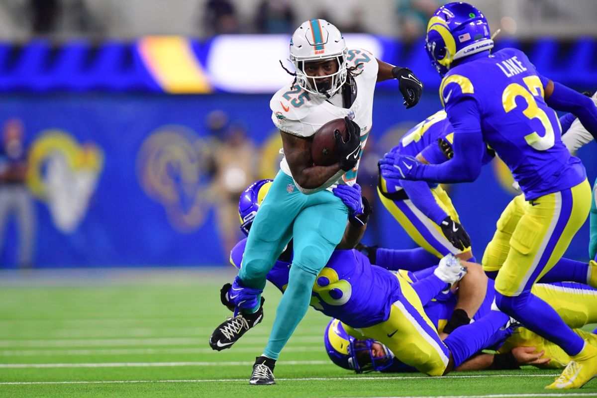 Nov 11, 2024; Inglewood, California, USA; Miami Dolphins running back Jaylen Wright (25) runs the ball against Los Angeles Rams safety Quentin Lake (37)  during the first half at SoFi Stadium. Mandatory Credit: Gary A. Vasquez-Imagn Images