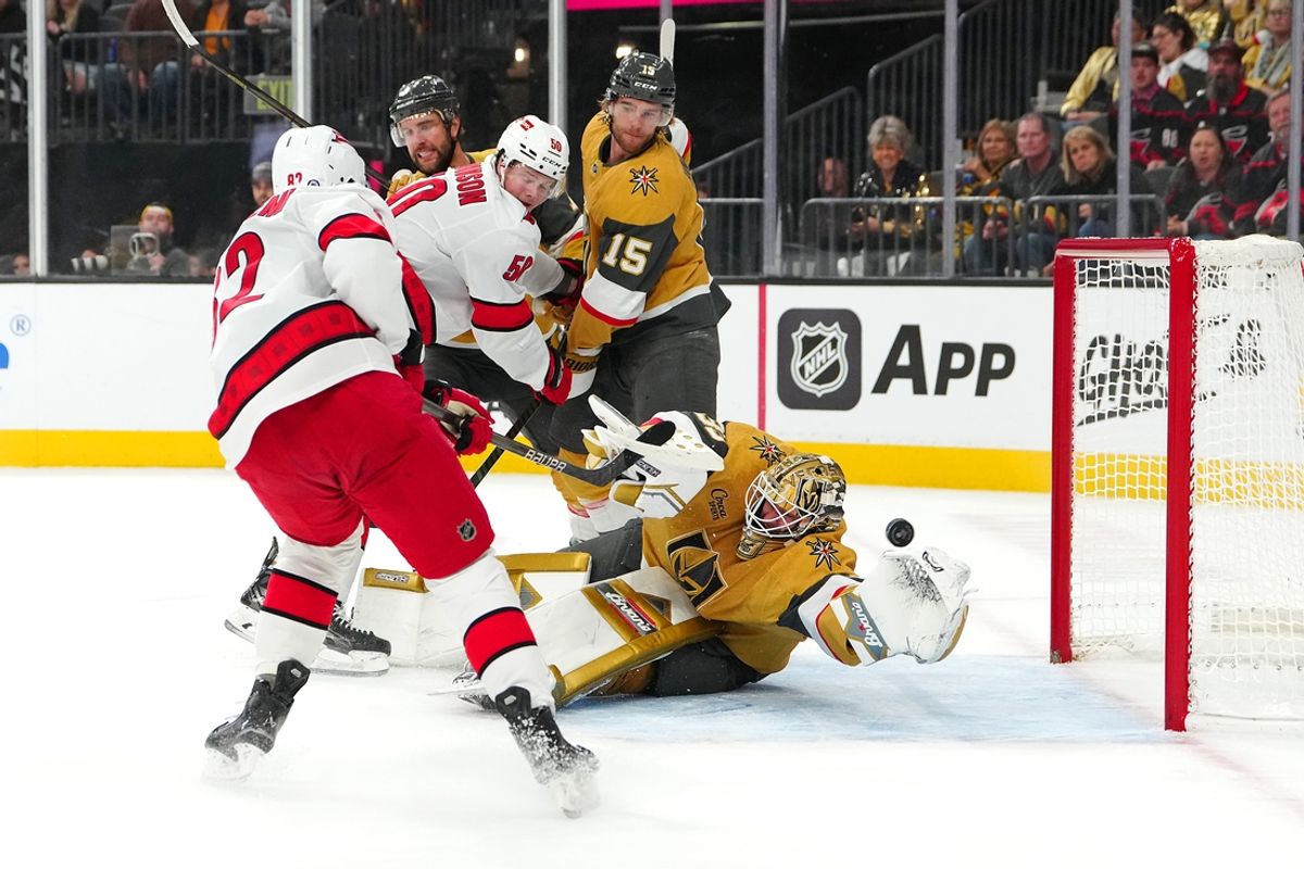 Nov 11, 2024; Las Vegas, Nevada, USA; Carolina Hurricanes center Jesperi Kotkaniemi (82) scores against Vegas Golden Knights goaltender Adin Hill (33) during the first period at T-Mobile Arena. Mandatory Credit: Stephen R. Sylvanie-Imagn Images
